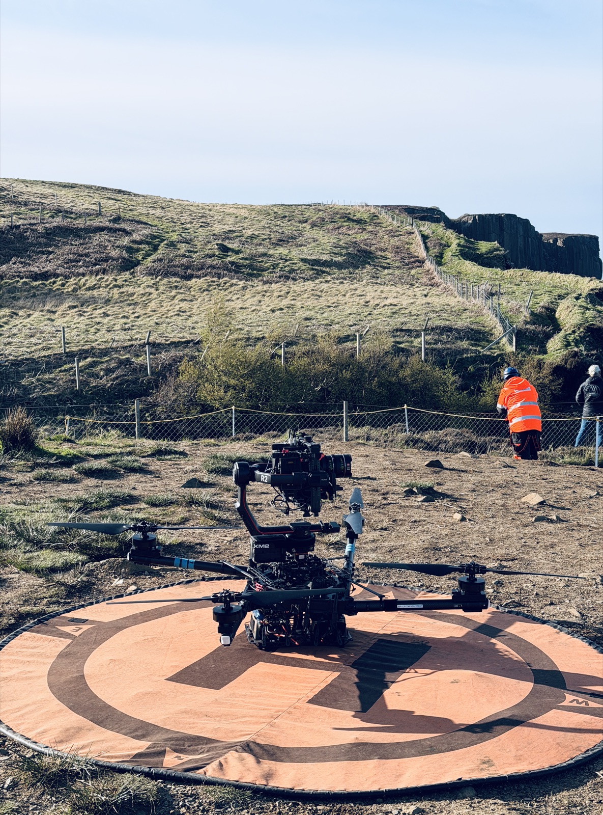 Alta X heavy-lift drone with ARRI camera on a landing pad by coastal cliffs
