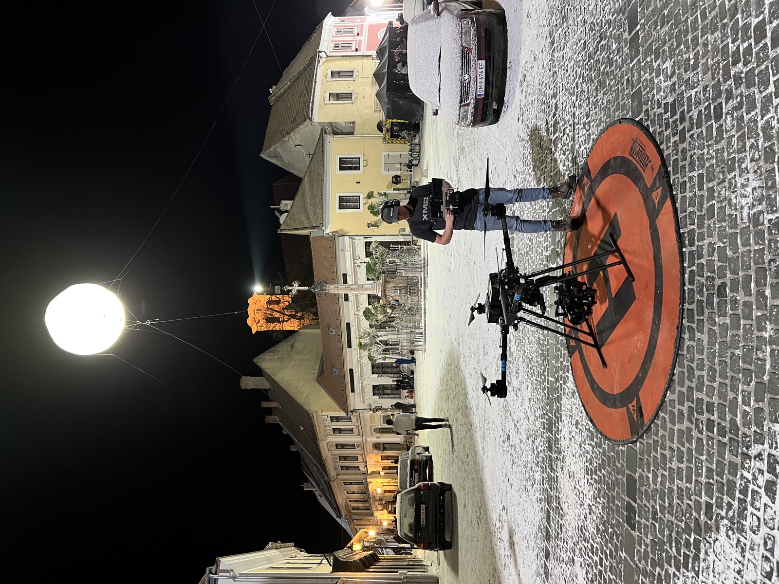 Night shoot on a snowy town square with a heavy-lift drone and balloon light